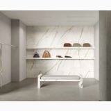 Gresie Portelanata Italgraniti Calacatta Top 60x120 cm Mat – ambient comercial, showroom cu perete marmura, banca si rafturi cu genti