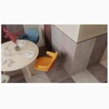 Gresie Concrete Dust 120x120X0.48 cm – ambient living, masa rotunda cu scaune colorate, gresie mare pe pardoseala si perete