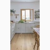 Parchet TripluStratificat Kahrs Edelweiss Mat 18,7x200 cm – ambient bucatarie, bucatarie deschisa cu mobilier alb si masa lemn, pe pardoseala