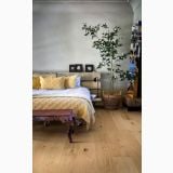 Parchet TripluStratificat Kahrs Stejar Aster Mat 18,7x200 cm – ambient dormitor, dormitor cu pat lemn, pernele galbene si copac interior, pe pardoseala