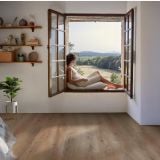 Parchet SPC Kahrs RABICANO CLICK 228 x 1220 x 5 mm – ambient living, femeie relaxata la fereastra cu parchet deschis, pe pardoseala
