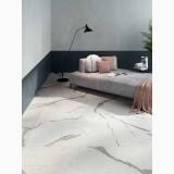 Gresie Abk Statuario Versilia Mat 120x120 cm – ambient dormitor, pardoseala marmura alba cu canapea gri si perete bicolor