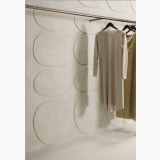 Gresie I Travertini Bianco Vein Cut 60x120 cm – ambient comercial, perete placat cu forme ovale, rochii pe umeras