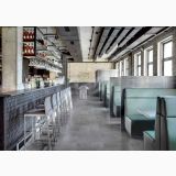 Gresie Ardesie Grigio Plus Mat 30x60 – ambient comercial, bar industrial cu pardoseala gri si canapele verzi