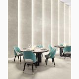 Gresie Gigacer Concept 1 Milk Mat 60x120 cm – ambient comercial, restaurant elegant cu perete iluminat si scaune turcoaz