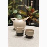 Gresie Gigacer Concept 1 Milk Texture Lucios 30x120 cm – vase ceramice bej si negru pe masa, plante in fundal