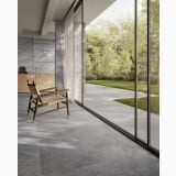 Gresie Bergstone Dark 120x120 cm – ambient living, terasa gri cu fotoliu lemn si vedere gradina, pe pardoseala