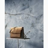 Gresie Portelanata HPM 02 Onice Azzurro Lucios 120x120 cm – ambient comercial, perete gresie onix albastru cu geanta expusa pe suport