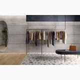 Gresie Form Story Grey 90x90 cm – ambient comercial, showroom cu rastel haine pe pardoseala tip terrazzo