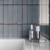 Gresie Portelanata Tetris Artic Lucios 5X20 cm – ambient baie, perete faianta albastra lucioasa cu produse cosmetice pe blat