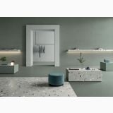Lastra gresie Nuances Grigio Coccio Mat 120x280x0.6 cm – ambient comercial, showroom minimalist cu pardoseala terrazzo gri si pufuri turcoaz