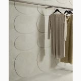 Gresie Portelanata I Cementi White 30x60 cm – ambient comercial, perete placat cu forme ovale, showroom haine cu bara umerase