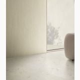 Gresie Portelanata Decor I Cementi White Ciottolo 60x120 cm – ambient living, living cu perete striat bej si fotoliu maro, pe pardoseala