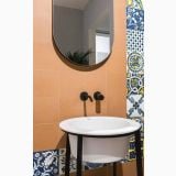 Gresie Vita Cotto Mat 20x20 cm – ambient baie, baie cu perete portocaliu, oglinda ovala si robinet negru