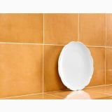 Gresie Vita Arancione Lucios 20x20 cm – ambient baie, farfurie alba sprijinita pe gresie portocalie lucioasa, pe pardoseala si perete