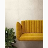 Gresie Inclusioni Soave Bianco Perla Soft 60x60x1.2 cm – ambient living, canapea galbena catifea pe perete gresie deschisa