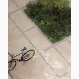 Gresie Bergstone Ivory Antislip 120x120 cm – ambient exterior, terasa exterioara cu gresie mare, gravel si vegetatie, bicicleta, pe pardoseala