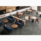 Gresie Shale Ash Antislip 60x120 cm – ambient comercial, spatiu lounge cu canapele albastre si mese rotunde, pe pardoseala