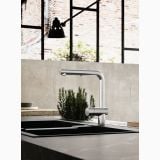 Robinet Lavoar Bucatarie Paffoni Light Finisaj Metalic – ambient bucatarie, robinet metalic pe blat negru, plante verzi, cadru industrial