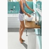 Baterie Lavoar Hansgrohe Logis E 230 Finisaj Crom – ambient baie, femeie se spala pe maini la lavoar cu baterie crom, pe perete