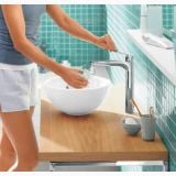 Baterie Lavoar Hansgrohe Logis E 230 Finisaj Crom – ambient baie, femeie spala mainile la lavoar cu baterie crom, pe perete