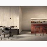 Faianta I Travertini Rosso Vein Cut Ribbed 60x120 cm – ambient comercial, bar cu pereti travertin bej si scaune negre, pe perete