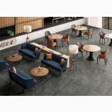 Gresie Shale Ash Mat 80x160 cm – ambient comercial, spatiu lounge cu canapele albastre si mese rotunde, pe pardoseala