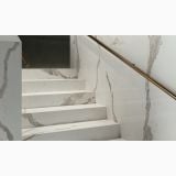 Gresie Abk Statuario Versilia Mat 120x280x0,6 cm – ambient hol, scara marmorata cu balustrada aurie si perete asortat