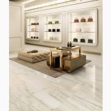 Gresie Akoya Ivory Mat 30x60 cm – ambient comercial, showroom cu pardoseala marmorata, vitrine si masuta aurie
