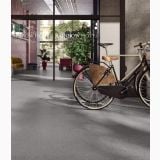 Gresie Deconcrete Micro Grey 60x60 cm – ambient comercial, lobby hotel cu bicicleta si pardoseala gri texturata