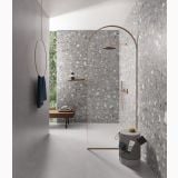 Gresie Deconcrete Medium Grey 60x60 cm – ambient baie, baie cu perete terrazzo si dus arcuit auriu, pe pardoseala
