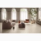 Gresie Deconcrete Medium Sand 90x90cm – ambient living, living spatios cu canapea maro si fotolii portocalii, pe pardoseala