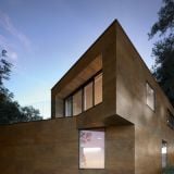 Gresie Oxidart Black 90x90 cm – ambient exterior, casa moderna cu fatada placata, geamuri mari, seara, pe perete